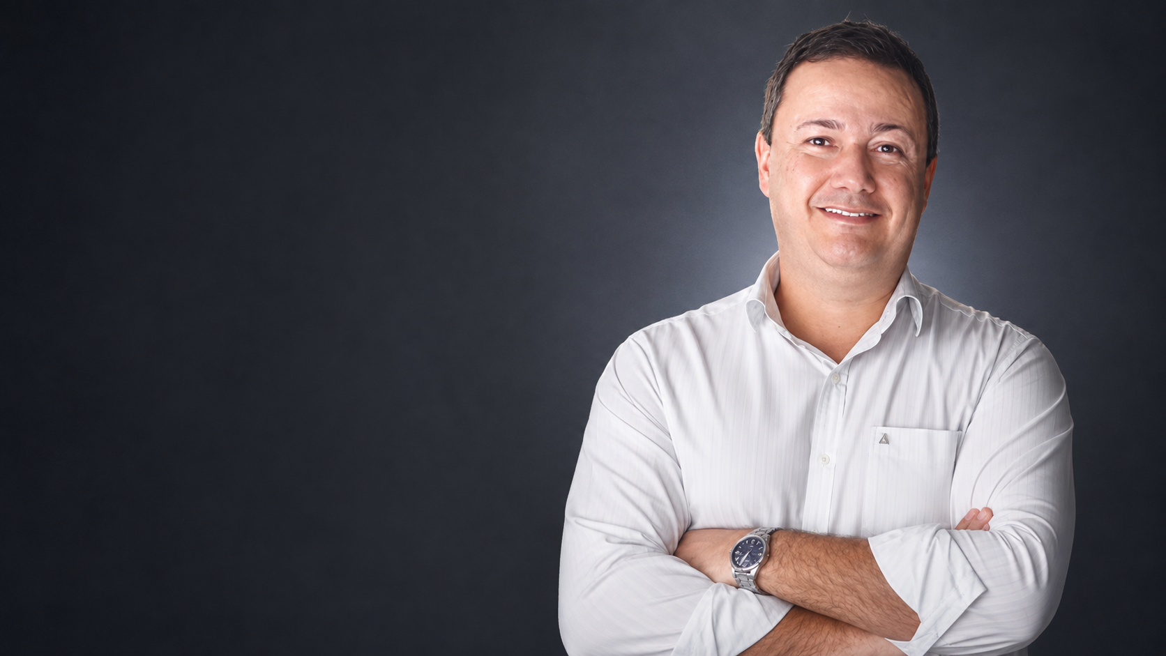 Leonardo Bianchini, especialista em cozinhas comerciais e industriais, de braços cruzados e camisa branca, em retrato de estúdio